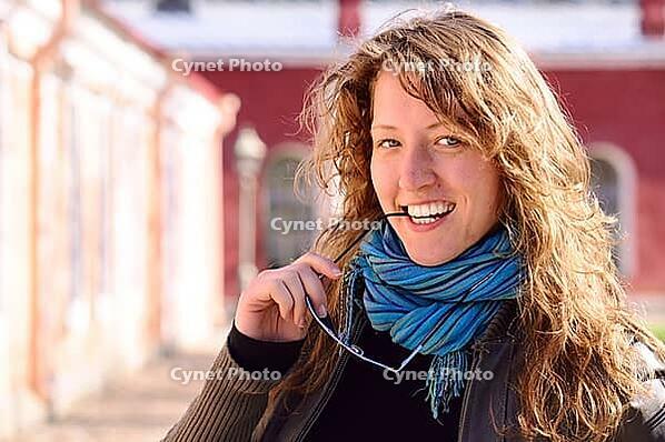 Beautiful smart woman is looking at camera and biting her glasses [IBR124906348]