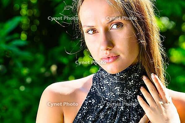 Sexy young woman in trees at sunny weather [IBR124906353]