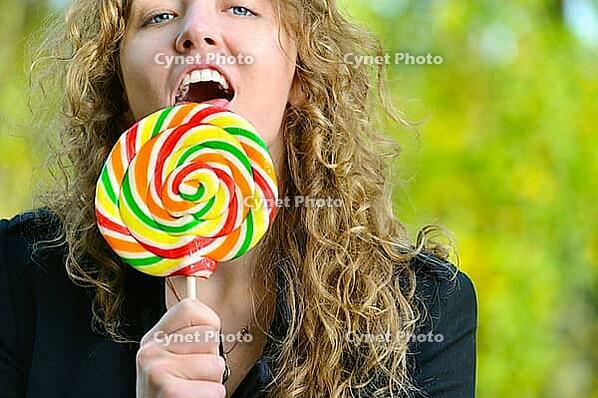 Woman is licking a huge lollipop [IBR124906359]