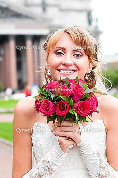 Cheerful bride is holding wedding bunch of roses [IBR124906383]