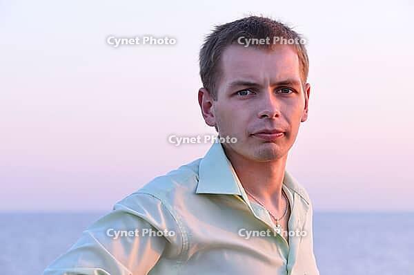 Serious adult man at sunrise near the sea [IBR124906388]