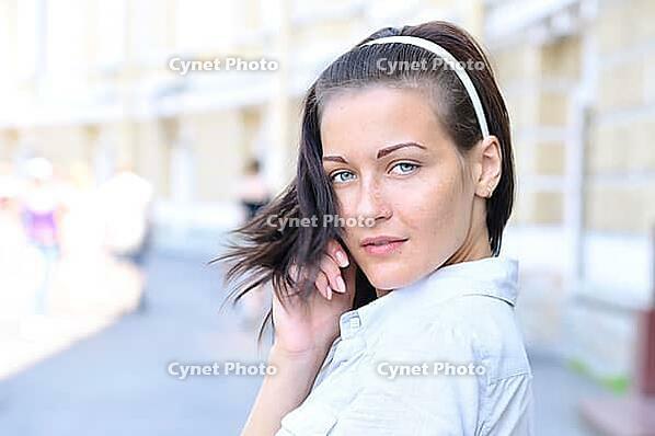 Sensual woman is looking back at sunny street [IBR124906392]