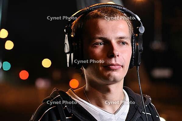 Man listening music at city night street [IBR124906394]
