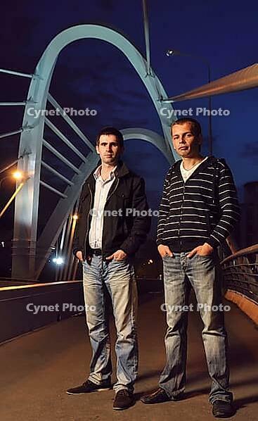 Two guys standing on the night bridge and looking at camera [IBR124906405]