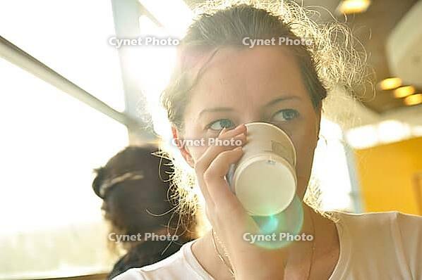 Woman is drinking from paper cup [IBR124906409]