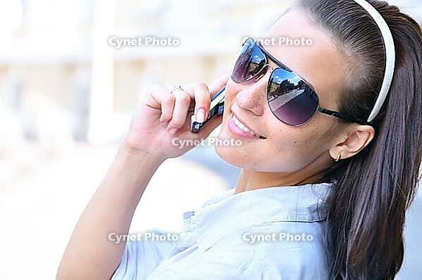 Happy woman is looking back and talking phone [IBR124906414]