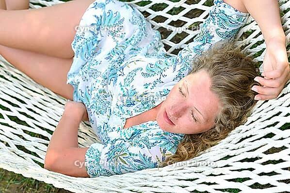 Sexy woman is lying in hammock at summer in park [IBR124906430]