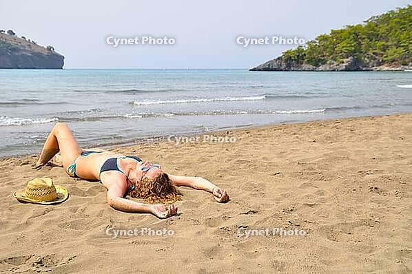 Sexy woman is lying on the wild beach [IBR124906433]
