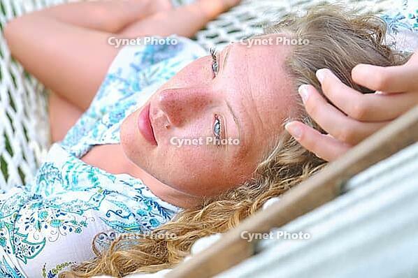 Sexy woman is lying in hammock and looking sideways [IBR124906434]