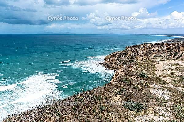 View of a rocky coast by the sea under a slightly cloudy sky, near Setubal in spring 2019 [IBR124915278]