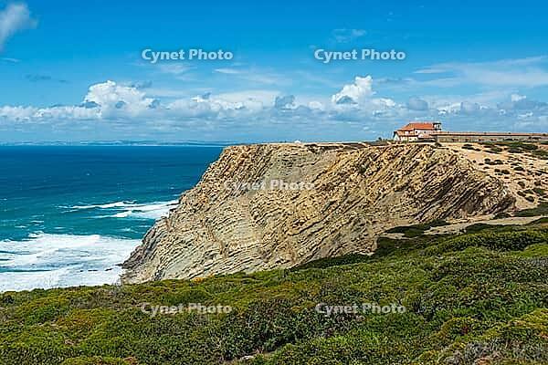 View of a rocky coast by the sea under a slightly cloudy sky, near Setubal in spring 2019 [IBR124915279]