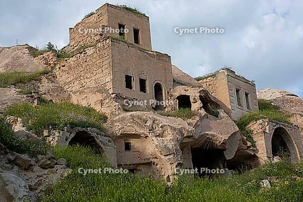 Scenic landscape featuring ancient cave dwellings carved into unique fairy chimneys in Cappadocia central Turkey [IBR124920177]