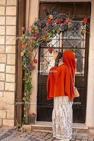 Traveling woman captures images while exploring charming old town architecture and culture [IBR124920192]