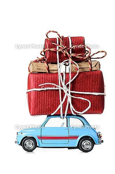 Blue retro toy car delivering Christmas or New Year gifts, isolated on white [IBR124944046]