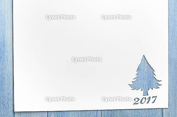 Cut paper in christmas tree shape for christmas card or new year background on wooden table [IBR124944055]