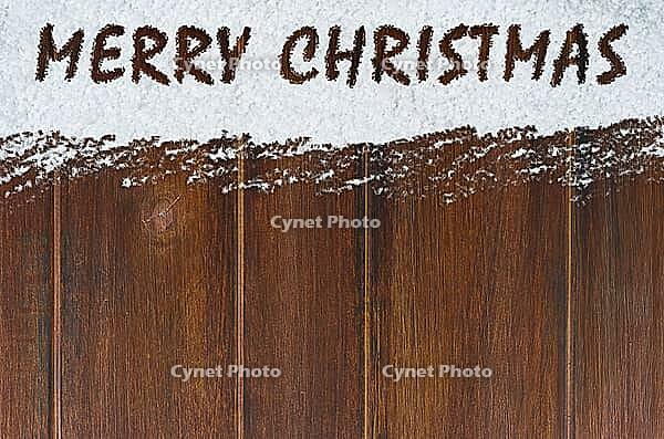 Merry christmas handwritten on snow and wooden table [IBR124944057]