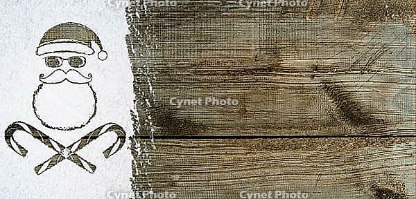 Bad Santa Claus symbol handwritten on christmas or new year card made of snow background over wooden table [IBR124944063]