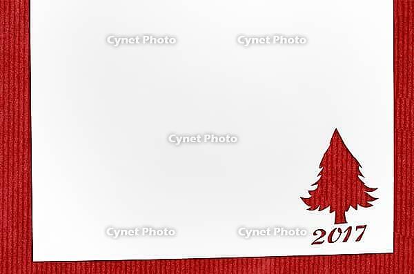 Cut paper in fir-tree shape for christmas card or new year background on red table [IBR124944068]