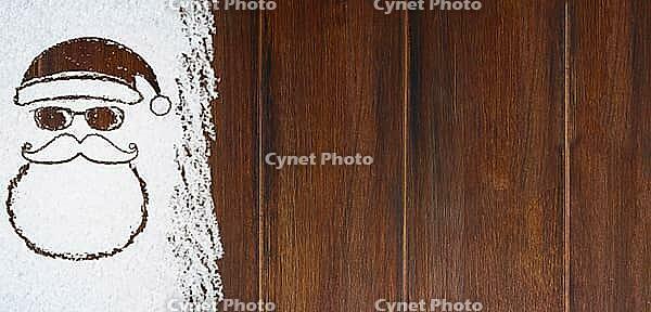 Christmas card or new year background made of santa claus symbol handwritten on snow and wooden table [IBR124944070]