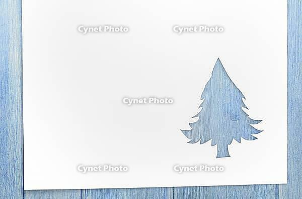 Cut paper in christmas tree shape for christmas card or new year background on wooden table [IBR124944074]