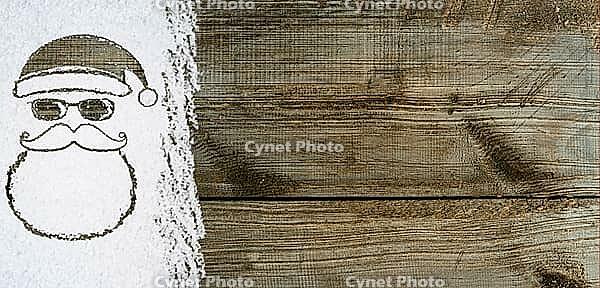 Christmas card or new year background made of santa claus symbol handwritten on snow and wooden table [IBR124944090]