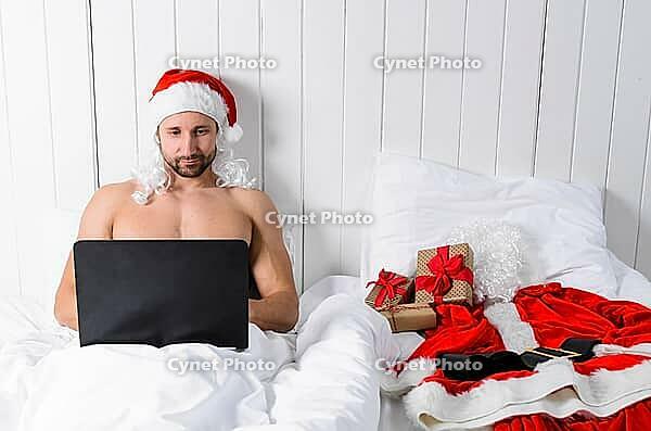 Santa Claus in hotel room without costume shopping for Christmas or New Year [IBR124944121]