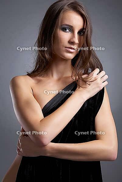Attractive young model covers her chest with black cloth [IBR124968418]