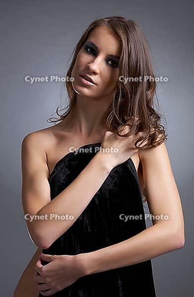Attractive young model covers her chest with black cloth [IBR124968422]