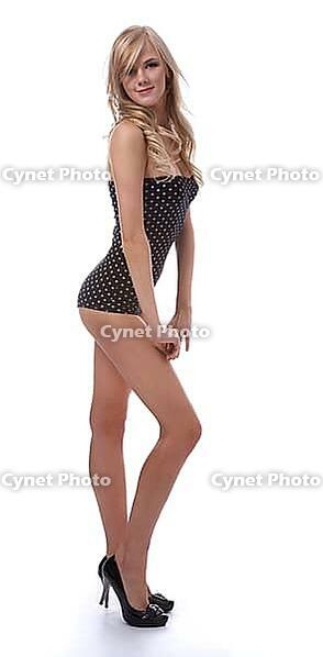 Portrait of beautiful blonde model poses in polka-dot body on white [IBR124968431]