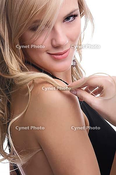 Close-up portrait of beautiful sensual blonde model poses looking over her shoulder and slightly touches her hair [IBR124968432]
