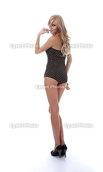 Portrait of beautiful blonde model poses in polka-dot body on white [IBR124968433]