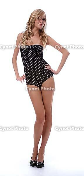 Portrait of beautiful blonde model poses in polka-dot body on white [IBR124968449]