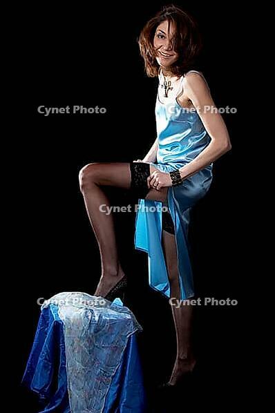 Woman in blue peignoir and tights isolated on the black background [IBR124968452]