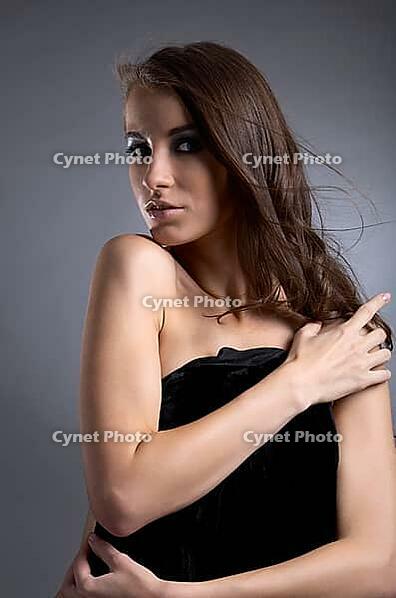 Attractive young model covers her chest with black cloth [IBR124968468]