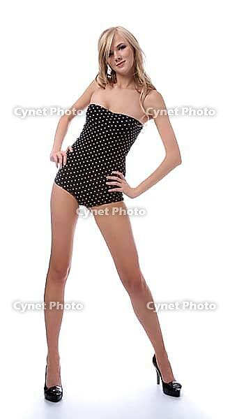 Portrait of beautiful blonde model poses in polka-dot body on white [IBR124968471]