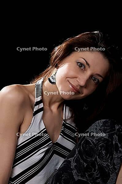 Dark-haired women in striped blouse isolated at the black background [IBR124968476]