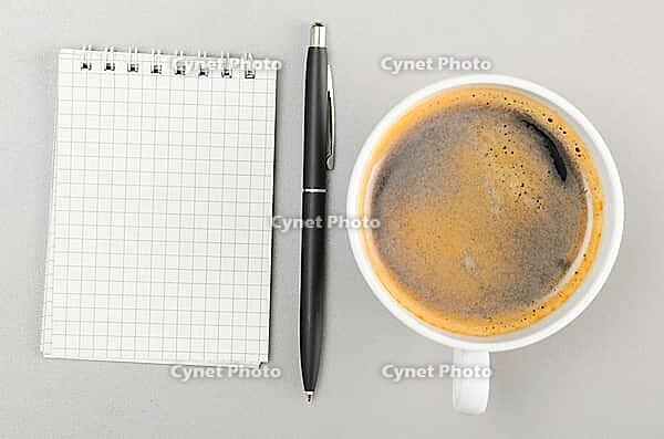 Creative process. blank notebook and cup on gray [IBR125000243]