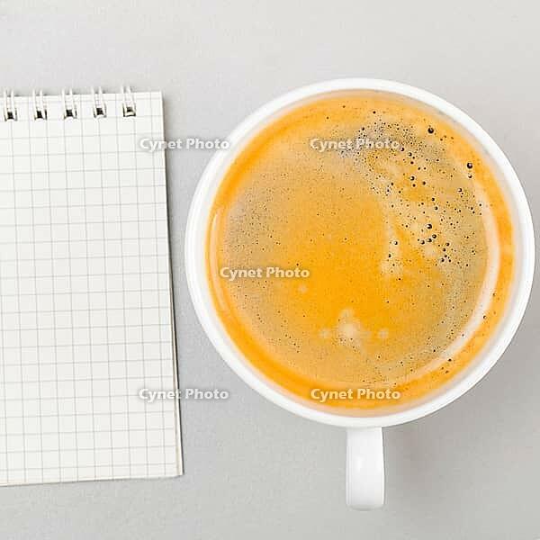 Creative process. blank notebook and cup on gray [IBR125000245]