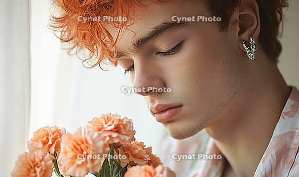 Closeup portrait of a young man with peach-colored hair, silver earrings, holding peach carnations. AI generated [IBR125000297]