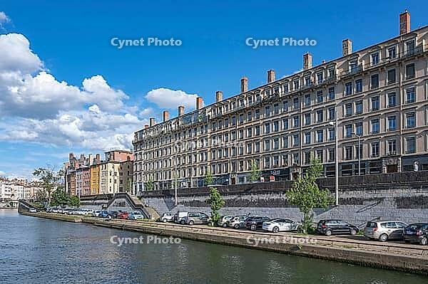 Classicist residential buildings on Quai Fulchiron stretch along the quay wall of the Saone River in the historic Vieux Lyon district under blue summer skies in Lyon, Vieux Lyon, Metropole de Lyon, Rhone, Auvergne-Rhone-Alpes, France [IBR125002336]