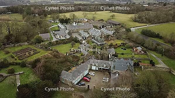 Aerial view of a rural manor surrounded by well-kept gardens and trees, set in a countryside landscape, Farm in Wales, United Kingdom [IBR125026137]