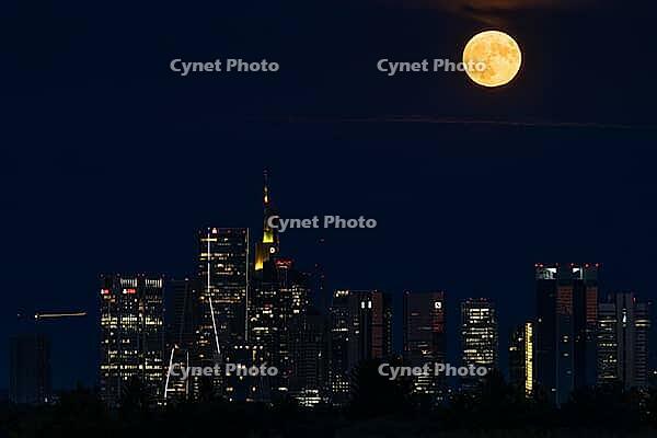 The full moon sweeps across Frankfurt's banking skyline. In June, the full moon is traditionally called the strawberry moon and refers to the strawberry harvest. Rose moon because of the rose blossom and honey moon because of the honey harvest are also tr [IBR125026180]