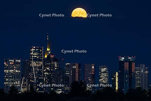 The full moon sweeps across Frankfurt's banking skyline. In June, the full moon is traditionally called the strawberry moon and refers to the strawberry harvest. Rose moon because of the rose blossom and honey moon because of the honey harvest are also tr [IBR125026188]