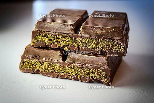 Dubai chocolate with pistachio cream filled center. sliced and stacked for presentation. macrophotography close-up background [IBR125026214]