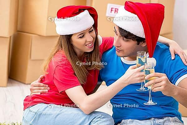 Young family celebrating christmas in new home [IBR125053200]