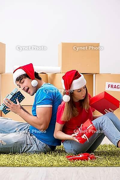Young family celebrating christmas in new home [IBR125053201]