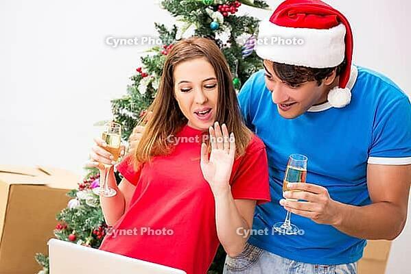 Young family celebrating christmas in new home [IBR125053203]