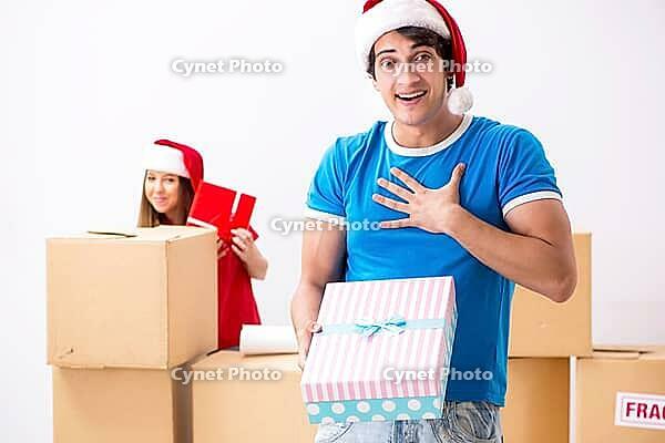 Young family celebrating christmas in new home [IBR125053210]