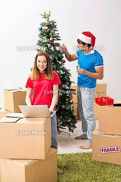 Young family celebrating christmas in new home [IBR125053211]