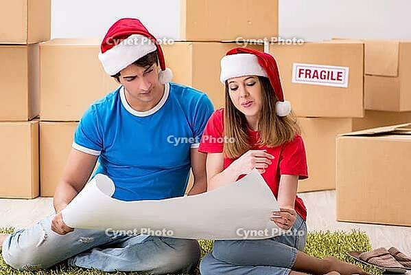 Young family celebrating christmas in new home [IBR125053215]